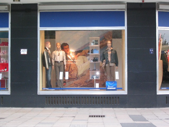 zwei bildungsbuerger sitzen auf einer bank, und photographieren ein schaufenster ...